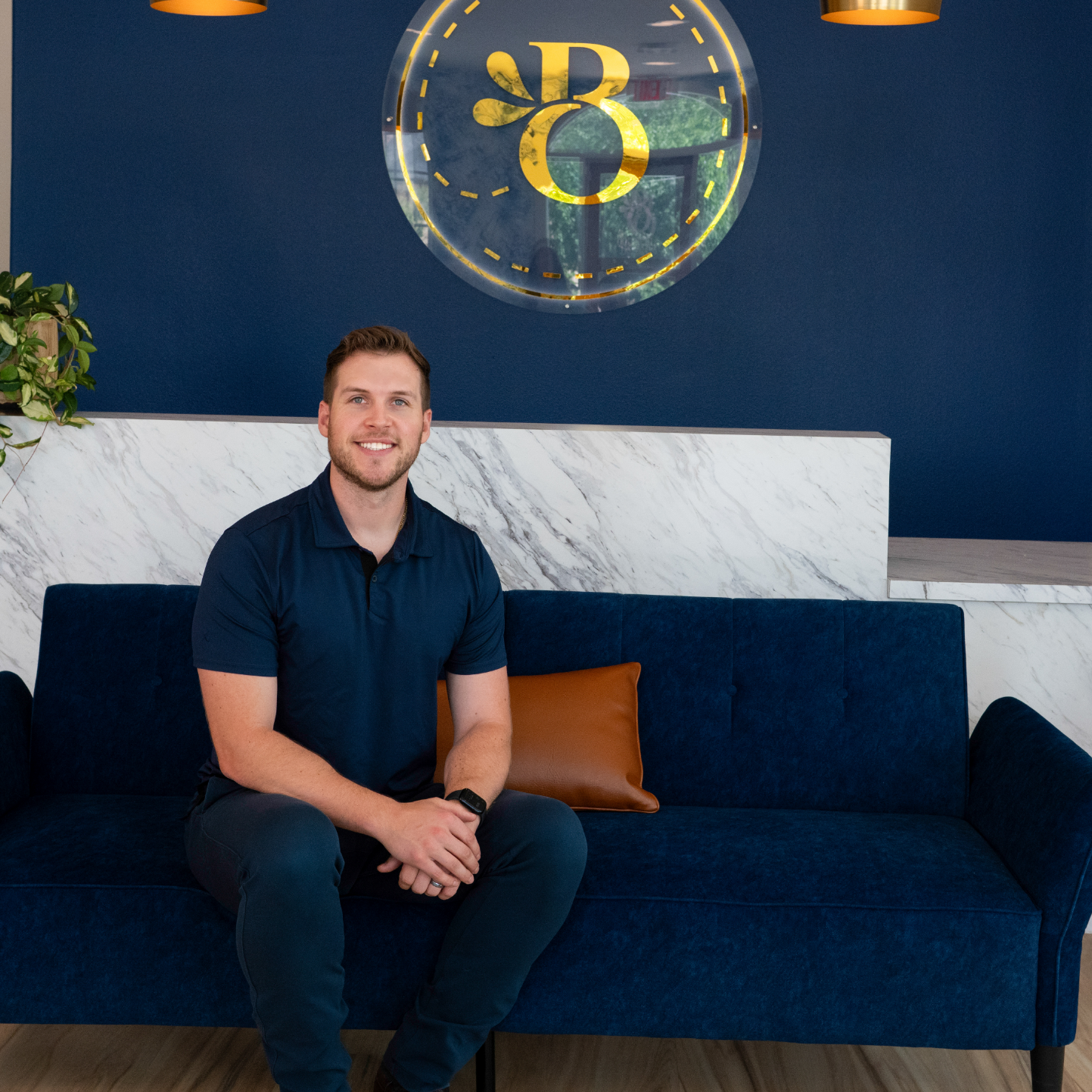 Benbrook orthodontist Doctor Eric Bortnem sitting on a dark blue couch.