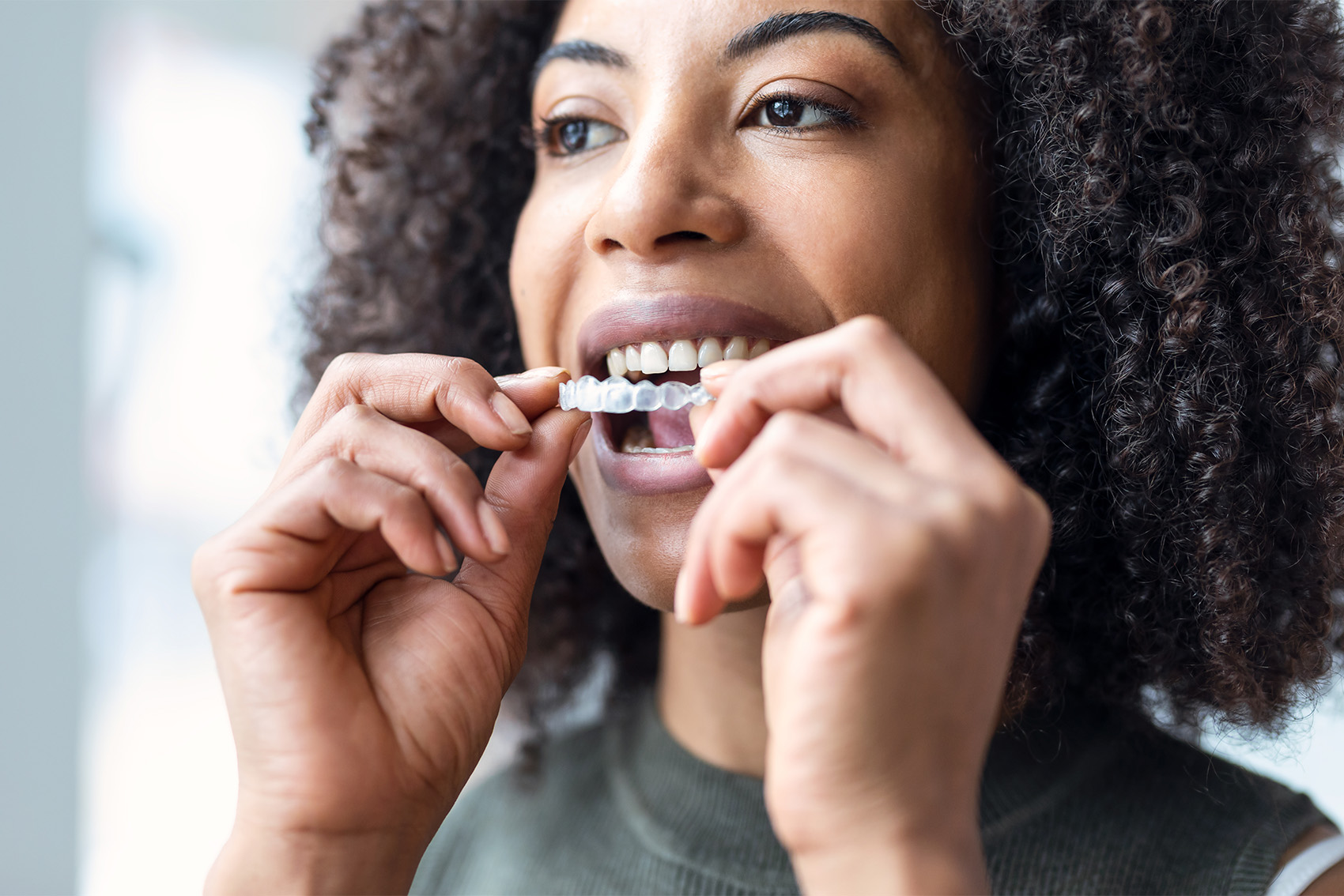 Woman holding clear aligners.